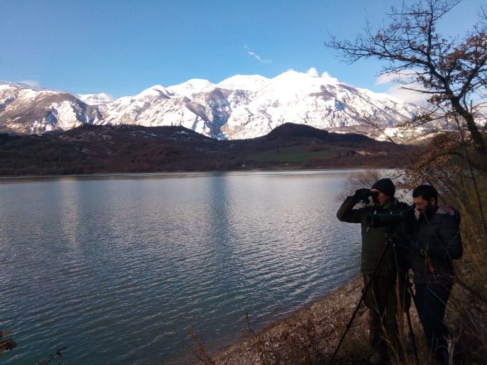 Due membri dello IAAP monitorano il territorio delle aree protette, una montagna innevata gli fa da sfondo